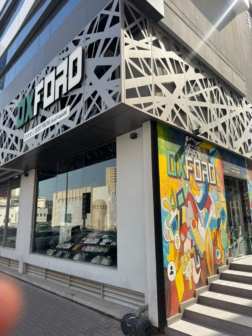 The OXFORD store frontage, showing its green OX sign and monochrome exterior